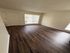 Bright and inviting living space with elegant dark wood flooring and ample natural light from large windows.