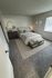 Cozy bedroom with stylish decor, featuring a comfortable bed, soft carpeting, and elegant lighting.