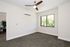 Bright, airy bedroom featuring a modern ceiling fan, large window with scenic view, and plush carpeting.
