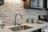Modern kitchen with sleek stainless steel appliances, elegant tile backsplash, and contemporary cabinetry.
