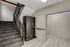 Modern apartment entrance featuring a sleek package locker, carpeted stairs, and warm ambient lighting.