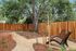 Serene backyard oasis featuring a cozy lounge area, lush greenery, and a majestic tree, perfect for relaxation.