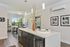 Modern apartment interior showcasing a bright, open kitchen with sleek countertops, stylish dining area, and contemporary decor accents with lush greenery views through large windows.