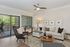 Contemporary living room with a cozy sectional sofa, elegant decor, and large windows leading to a serene balcony view.