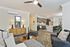 Modern open-concept living area with elegant kitchen and cozy seating, featuring stylish decor and abundant natural light.