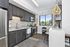 Modern kitchen with sleek dark cabinetry, stainless steel appliances, and a stylish pendant light accenting the contemporary design.