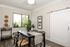 Charming dining room with modern decor, featuring a sleek black table, stylish chairs, and large window offering natural light. Decor includes vibrant greenery and elegant wall art.