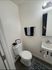 Elegant bathroom with sleek fixtures, featuring a chic black and white theme, cozy towel arrangement, and stylish wall art.