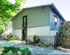Charming two-story apartment building with modern design, lush greenery, and secure fencing, creating a welcoming curb appeal.