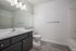 Elegant bathroom featuring modern fixtures, spacious vanity with ample storage, and sleek gray cabinetry complementing polished flooring.