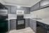 Modern kitchen with sleek gray cabinets, refinished countertops, and stainless steel appliances, offering a stylish and functional cooking space.