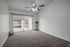 Bright and spacious living room with modern ceiling fan, featuring a private balcony access.