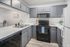 Modern kitchen with sleek gray cabinetry, stainless steel sink, and contemporary appliances, ideal for culinary adventures.