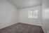 Bright, open bedroom featuring carpet and a large window with blinds, providing ample natural light.