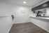 Modern kitchen with sleek grey cabinets, polished countertops, and stylish flooring, creating a bright and inviting space.