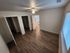 Bright and spacious bedroom with modern wooden flooring, ample natural light, and dual closets for optimal storage.