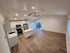 Spacious open-concept kitchen and living area with sleek cabinetry and hardwood flooring, perfect for modern living.