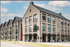 Stylish modern apartment building with large windows and outdoor seating.