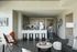 Bright open living area with a modern kitchen, bar stools, cozy seating, and stylish decor.