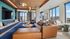 Chic urban lounge area with modern decor, large windows, and cozy seating, offering stunning city views.