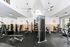 Modern apartment fitness center featuring state-of-the-art gym equipment, bright high ceilings, and stylish design.