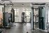 Modern fitness center with high-end gym equipment, including a punching bag and elliptical, set against stylish wall decor and large windows for natural light.