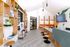 Modern lobby area featuring elegant wooden shelving, stylish seating, and vibrant decor with a contemporary aesthetic.
