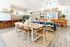 Modern open-concept living space featuring a chic dining area, stylish shelving, and vibrant decor, offering a bright and inviting atmosphere.