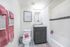 Bright and modern bathroom featuring stylish design with a granite-topped vanity, elegant wall art, and plush towels for a luxurious feel.