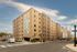 Modern apartment building with unique colorful mural and spacious urban setting.