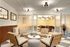Chic office lounge with modern seating and a stylish glass divider revealing a vibrant meeting room.