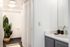 Bright and modern bathroom with sleek fixtures, elegant shower curtain, and a touch of greenery for a refreshing ambiance.