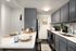 Modern kitchen with sleek gray cabinets, stainless steel appliances, and a cozy breakfast bar, enhanced by elegant d&eacute;cor and ample lighting.