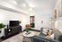 Chic living room with contemporary decor, stylish grey sofa, modern TV stand, and vibrant plant accents, exuding a cozy and inviting ambiance.