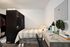 Chic bedroom with cozy bed, stylish desk, and modern decor, perfect for relaxation and productivity.