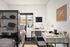 Modern bedroom and study space with sleek desk, comfortable chair, and cozy bed, enhanced by natural light from large window.