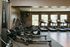 Modern fitness center featuring state-of-the-art treadmills and rowing machines with large windows providing natural light.