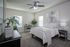 Modern bedroom with cozy decor featuring a plush bed, stylish desk, and inviting natural light.