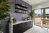 Chic modern kitchen corner with elegant marble countertop, stylish shelving, and vibrant greenery, creating a welcoming ambiance with a view of a sunlit patio.