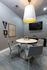 Chic modern meeting room with sleek grey chairs and a round table, complemented by stylish wall art and a large TV.