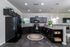 Contemporary kitchen with sleek black cabinetry, modern appliances, and elegant pendant lighting, ideal for stylish cooking and entertaining.