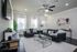 Modern living room featuring sleek black sofas, elegant decor, and a cozy ambiance with ample natural light.