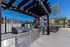 Chic outdoor kitchen with modern stainless steel grills under a stylish pergola, perfect for entertaining in a vibrant community setting.