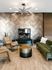 Luxurious living room featuring a modern fireplace, elegant green velvet sofa, chic beige armchairs, and stylish lighting against a herringbone accent wall.