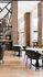 Chic modern apartment interior with stylish wooden accents, elegant dining area, and large windows for abundant natural light.