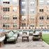 Charming apartment building with a stylish outdoor patio, featuring comfortable seating and a refreshing pool, perfect for relaxation.