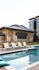 Luxurious apartment complex showcasing a modern outdoor pool area with stylish lounge chairs and a large entertainment screen.