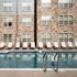 Inviting swimming pool with stylish lounge chairs set against a charming stone facade, perfect for relaxation and leisure.