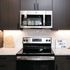 Modern kitchen with sleek stainless steel appliances, granite countertops, and inviting 'Home Sweet Home' sign, perfect for a cozy and stylish living space.