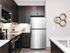 Modern kitchen with sleek stainless steel appliances, dark wood cabinets, and stylish granite countertops.